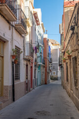 Fototapeta na wymiar Street with beautiful houses and flower in the old city of Alicante on a sunny day
