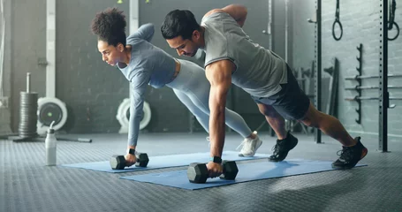 Photo sur Plexiglas Fitness Fitness, gym and couple plank with weight dumbbell for workout, strength and training lifestyle. Exercise, wellness and health of interracial people weightlifting for strong abdomen muscles.