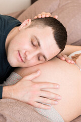 Pregnant woman with her husband in bed in the morning