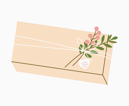 Gift in craft modern eco packaging. Wrapped gift with branch. DIY floral leaf decor. Holiday present. Tag in shape of heart. Giftbox pack. Gift box with plant decoration.