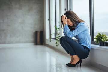 Businesswoman having problems in the office. Shot of a young businesswoman looking stressed out in...