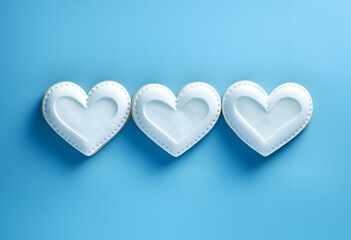 Decorated heart shaped cookies on blue background, top view
