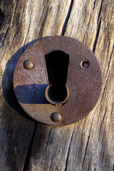 Old rusty lock on old wooden door in vertical