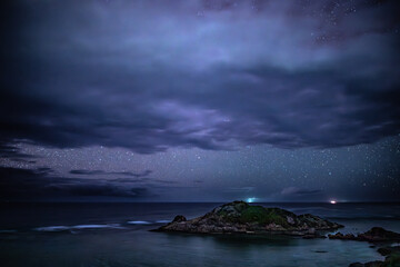 石垣島川平石崎にて海上の孤島平離島と夜空を覆う雲と星