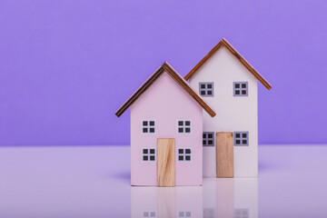 Charming cottages atop a white table against a purple backdrop. Ideal for showcasing cozy home decor or promoting countryside getaways. #HomeSweetHome