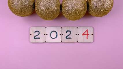the inscription 2024 on wooden cards surrounded by New Year's decorations