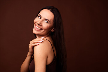 Profile portrait of lovely nice girl arm touch shoulder toothy smile look empty space isolated on brown color background