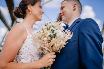 Valmiera, Latvia - July 7, 2023 - Close-up of a bride and groom on their wedding day, holding a...