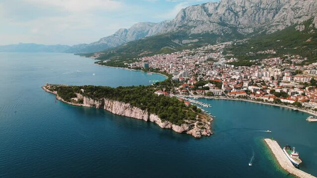 Makarska Riviera's Pristine Beaches and Urban Vista in Summer Bliss. Aerial view of a bustling seaside town with clear waters in Croatia.