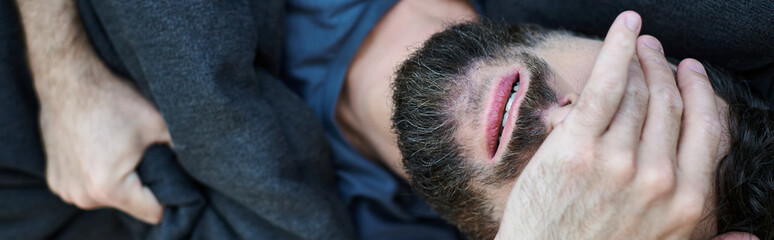 Naklejka premium frustrated man in casual home wear lying on sofa during breakdown, mental health awareness, banner