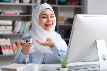 Woman giving of metal house keys and mini house