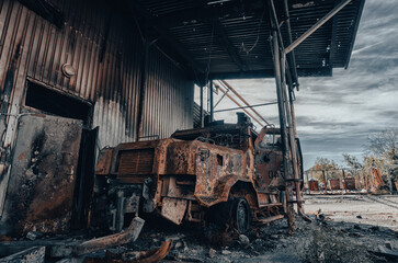 Fototapeta na wymiar burnt military armored car on the street of the ruined city