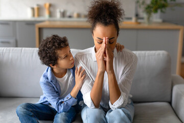 Concerned boy comforting stressed mother at home