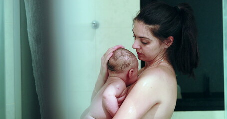 Candid mother bathing newborn baby infant in shower