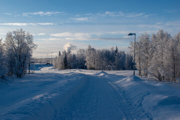Obraz premium Idyllic panoramic view of a beautiful white winter wonderland scenery in Scandinavia with scenic golden evening light at sunset in winter, northern Europe.