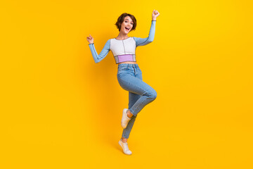 Fototapeta na wymiar Full length portrait of lovely delighted person raise fists success achievement isolated on yellow color background