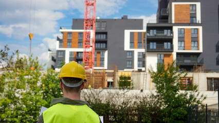 Construction worker looking at construction blueprint at a construction site - Stock photo