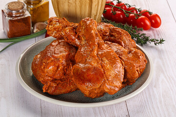 Raw turkey shoulder wing in Indian tandoori marinade