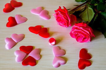 Valentines Day background. Red Roses with hearts on wooden background