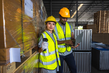 Black man factory worker and Caucasian colleague woman working in distribution warehouse