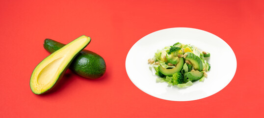 Green Salad with Avocado, Cucumber and Nuts on White Plate