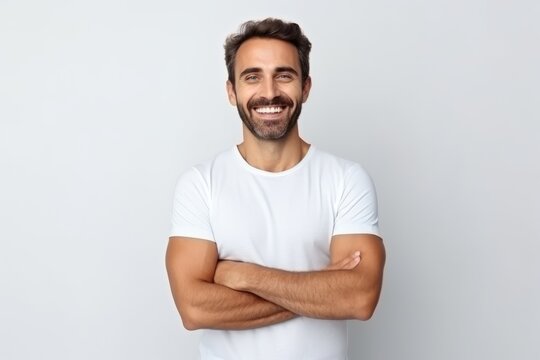 Portrait of a happy young man with arms crossed over grey background
