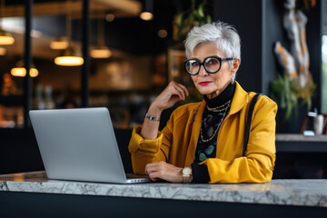stylish mature old woman working from caffe office on laptop. Smiling 60s middle aged business lady using computer