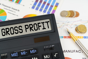 On the table are financial reports, coins and a calculator with the inscription - gross profit