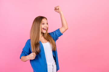 Photo of lucky excited girl wear blue shirt arms cheeks rising fists screaming yes looking empty...