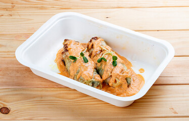 Stuffed cabbage rolls with salmon. Healthy food. Takeaway food. On a wooden background.