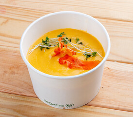 Pumpkin cream soup. Healthy food. Takeaway food.  On a wooden background.