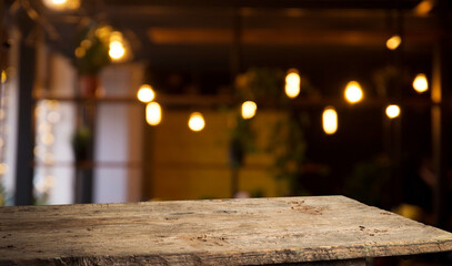 Empty wood table for product display in blur background of admirable restaurant at night. High...