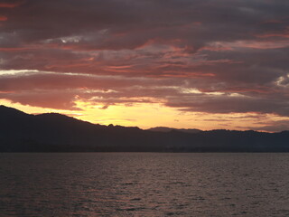 Sunset Over the Lake with Mountains and Clouds in the Background