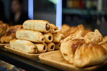 Varied selection of pastries and snacks in coffee shop. Bakery delicious food background, buffet catering. Golden puff pastry baked in the oven. Samsa, sausages in dough, kurnik.  © Sea_Inside_Soul