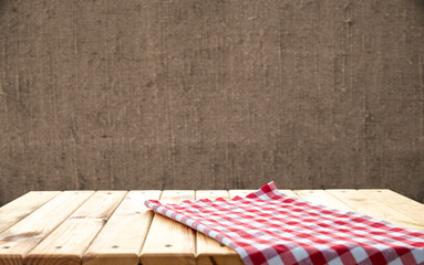 Retro background with wooden table and tablecloth over red rough wall. High quality photo