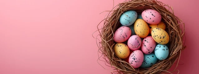 Fotobehang colorful easter eggs in a nest on pastel pink background, banner with copyspace, top view © Anastasia YU