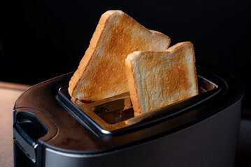 Modern toaster with crispy bread slices, closeup