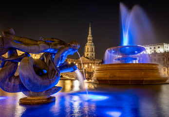 London. UK- 02.04.2024. A long exposure night time view of the water fountains in Trafalgar Square. - obrazy, fototapety, plakaty