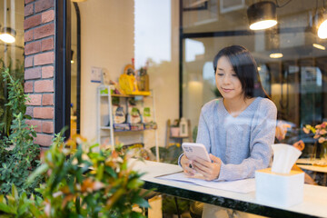 Fototapeta premium Woman use of mobile phone in coffee shop