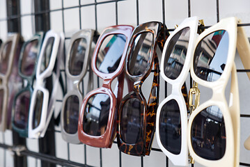 Variety fashion sunglasses displayed in market with selective focus.