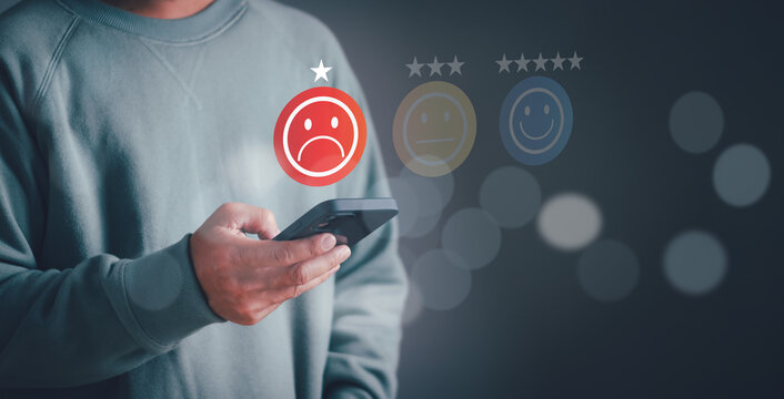 concept of bad experience or poor service and customers are not satisfied Low score in customer feedback evaluation, man using mobile phone with sad face icon Expressing great dissatisfaction