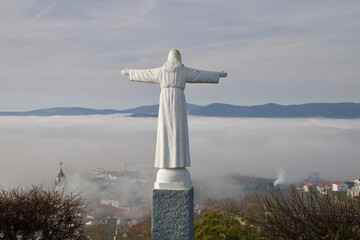 Statue on Santa Barbara Hill in Favaios with panoramic views above the clouds.