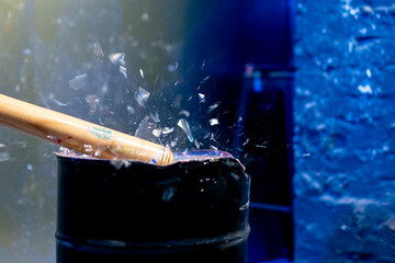 close up of a baseball bat smashing a glass in a destroy room for stress relief glass flies