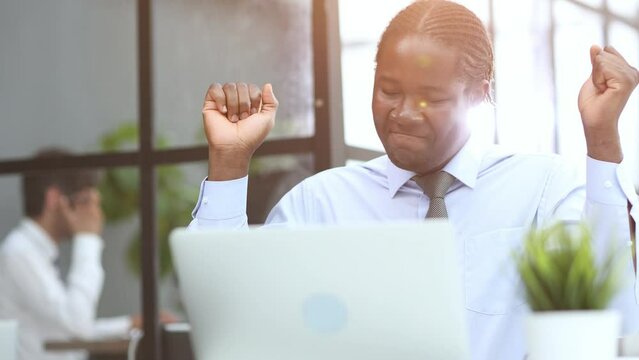 Funny young male worker standing in modern office hallway dancing