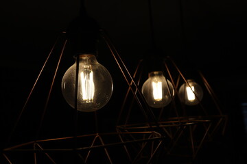 Three pendant lamps. Large round light bulbs on a chandelier. Electricity in the apartment....