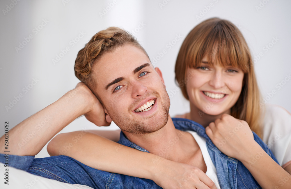 Sticker Happy, couple and couch with closeup portrait in home, hug and together in living room for happiness. Young, woman and man with smile on sofa in house for love, lounge and peaceful environment