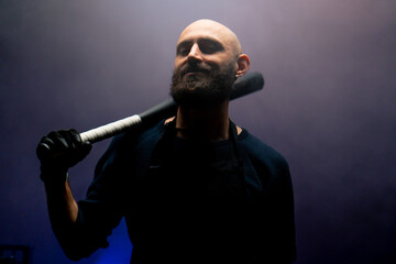 bald brazen robber with beard holding baseball bat during robbery attack crimes threats - obrazy, fototapety, plakaty