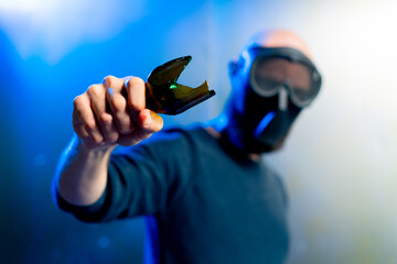 male robber in a mask holding a broken bottle in his hand threats attack robbery