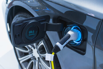 Close-up of an electric car being charged at a modern power station, showcasing sustainable transportation..