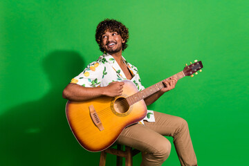 Photo of attractive young man sit chair look empty space guitarist dressed stylish citrus print...